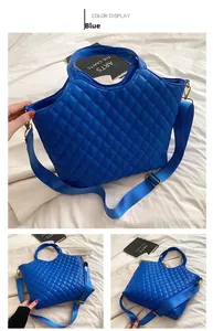 Blue quilted tote bag featuring diamond pattern stitching and adjustable shoulder strap
