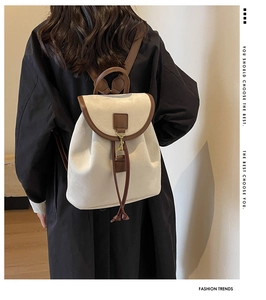 Vue arrière d'un mannequin portant un sac à dos vintage beige avec lanières en cuir brun