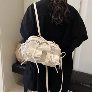 Large cream white Boston bag with bow pockets and adjustable strap shown on model