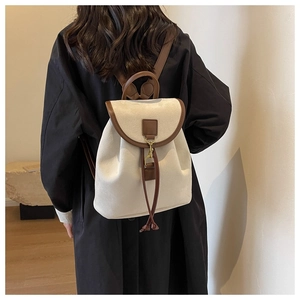 Vue arrière d'un sac à dos en toile beige avec garniture en cuir marron et cordon