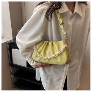 Detail der gelben Plissee-Tasche mit Perlenkette und gefaltetem Schulterriemen