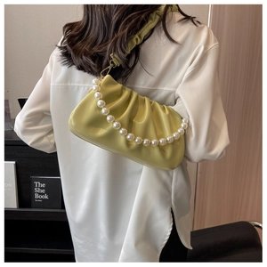 Detail of light green pleated cloud bag with elegant pearl chain and soft PU leather texture
