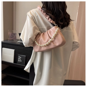 Detailed view of pink cloud bag with large pearl chain and pleated fabric shoulder strap