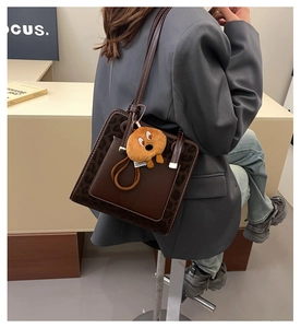 Detail of vintage brown shoulder bag with leopard print side panels and plush charm