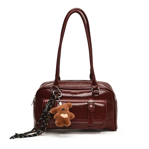 Glossy deep red patent leather Boston travel bag with plush bear charm and shoulder strap