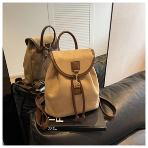 Détail d'un sac à dos en daim avec boucle mors dorée et fermeture à cordon coulissant