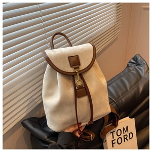 Vue détaillée d'un sac à dos en daim crème avec bordure brune et crochet métallique