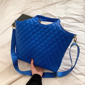 Quilted navy blue tote bag with adjustable wide strap and vintage gold hardware