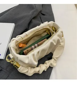 Detail view of the spacious inner compartment of the beige ruched cloud bag showing storage