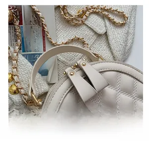 Détails des fermetures éclair dorées et texture en cuir matelassé d'un sac rond chic