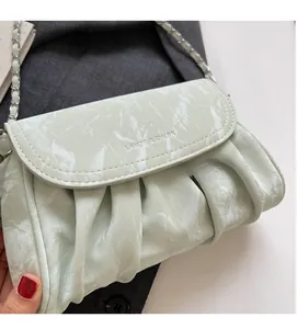 Détail du sac bandoulière plissé vert menthe avec texture marbre et chaîne argentée