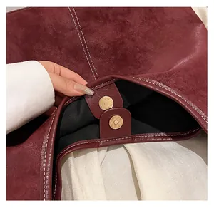 Detailed macro view of high-quality magnetic closure on a retro burgundy bucket bag