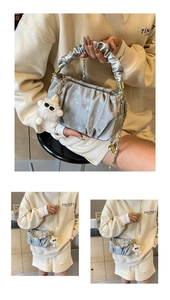 Close-up of silver pleated cloud bag with metal chain and white plush lamb charm