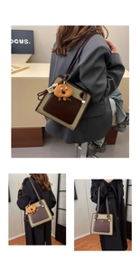 Detail view of retro color-block shoulder bag with cute orange plush dog charm accessory