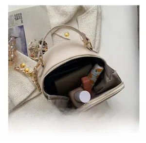 Vue de l'intérieur du sac matelassé crème avec produits cosmétiques essentiels