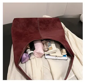 Spacious interior of burgundy faux suede tote bag holding gadgets and cosmetics