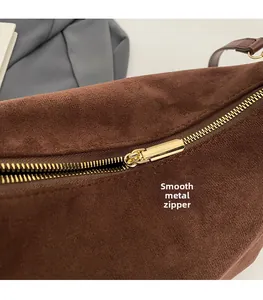 Detail of smooth gold zipper and hardware on a vintage dark brown suede underarm bag