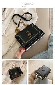 Detail of vintage black crossbody bag featuring bronze bee clasp and contrast piping