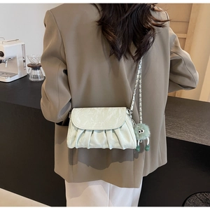 Détail du sac bandoulière plissé vert menthe avec chaîne argentée et breloque