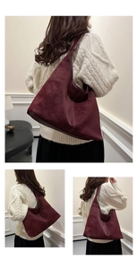Detailed view of the dark red suede bucket bag with contrast white stitching details