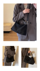 Macro view of matte black suede texture on shoulder bag with premium golden hardware