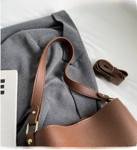 Close-up of caramel brown pebble leather tote bag with gold hardware and wide handle