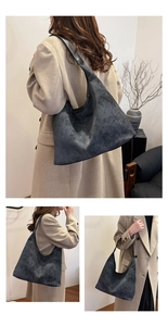 Detailed view of dark grey hobo bag featuring white contrast stitching and large capacity