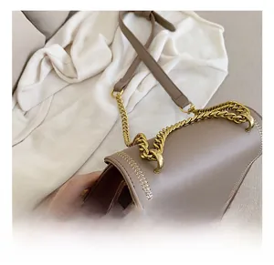 Detail showing high-quality leather stitching and antique gold bee buckle on crossbody bag