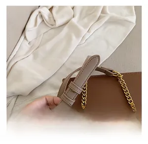 Detail of adjustable leather shoulder strap and gold chain on color-block crossbody bag