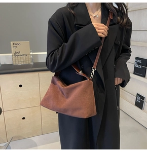 Brown frosted faux suede crossbody bag styled with a black oversize blazer in a studio