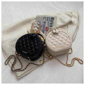 Détail de sacs à chaîne en cuir matelassé noir et beige avec pieds de protection en métal