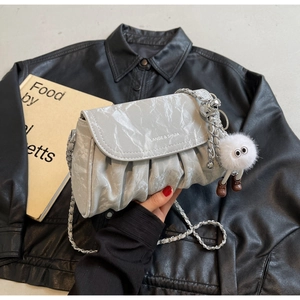 Détail du sac bandoulière gris plissé motif marbre avec logo argenté et charm en peluche