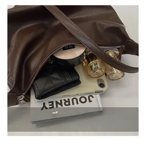 Close-up of brown leather shoulder bag interior showing large storage capacity