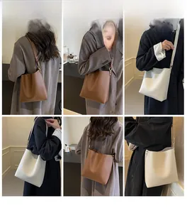 Detail view of large tote bags in brown and beige with minimalist textured leather