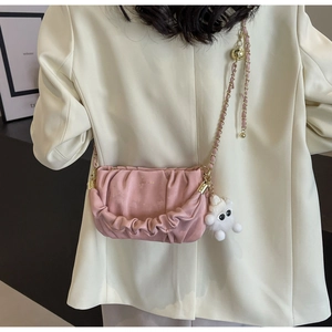 Pink pleated crossbody bag with gold chain and cute white plush doll accessory