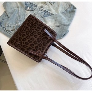 Macro shot of leopard print tote bag with white contrast stitching and denim detail