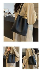 Detail of black lychee grain leather tote with gold hardware and adjustable strap