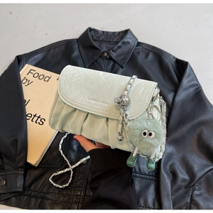 Détail du sac bandoulière plissé vert menthe avec chaîne argentée et breloque peluche
