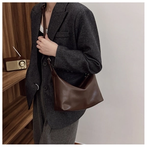 Detail view of a vintage dark brown shoulder bag with a sleek faux leather finish