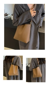 Detail of brown lychee-patterned bucket bag with adjustable strap and gold hardware