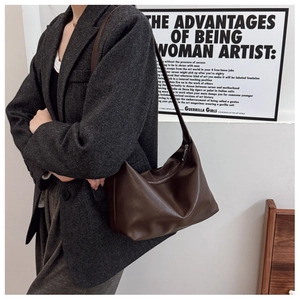 Deep brown leather half-moon tote bag styled with a grey herringbone wool blazer