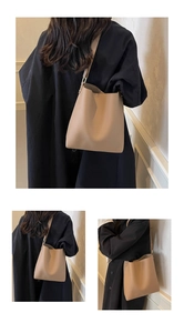 Macro detail of beige textured leather tote bag showing fine grain and sturdy shoulder strap