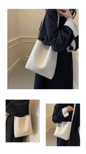 Detail shot of white bucket bag with pebble leather texture and metal rivet accents