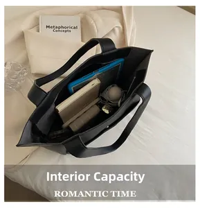Detail view of large black tote bag showing internal capacity with laptop and umbrella