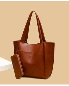 Detail of vintage brown PU leather tote bag set including a matching textured wallet