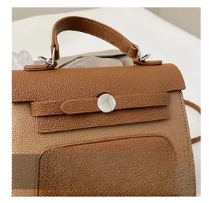 Close-up of brown litchi grain leather texture and silver zipper detail on the handbag