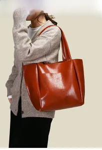 Detail of vintage brown oil-wax leather tote bag showing rich texture and glossy finish