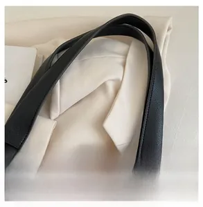 Detailed close-up of durable black lychee grain faux leather strap on a large tote bag
