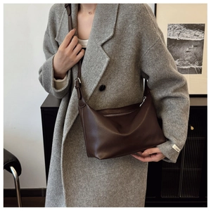 Detail of a dark brown leather hobo bag with adjustable strap for commuting