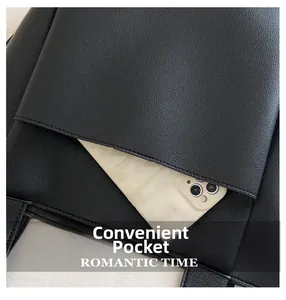Close-up of black lychee leather tote bag featuring a practical exterior pocket for a phone